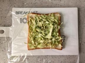 吐司片下垫一张保鲜膜，铺上一半的卷心菜。