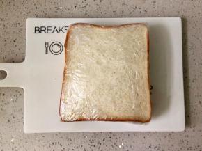 盖上另一片吐司，压紧，用保鲜膜裹紧