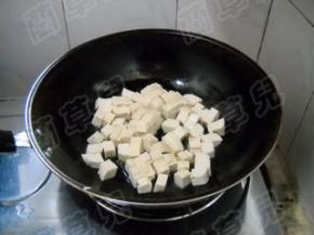 锅中油热，倒入豆腐。