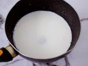 把纯牛奶倒入奶锅中，加入白糖