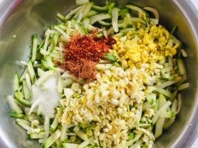 萝卜条中加入蒜末，姜末，1勺细辣椒面，1勺粗辣椒面，1汤匙白糖。