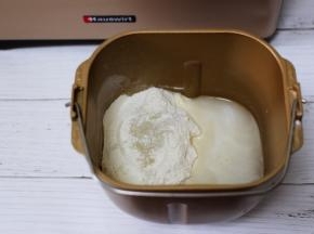 面包桶里加入称重面粉和清水及酵母。