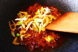 看见郫县豆瓣酱小火煸炒出红油后，加入葱姜丝爆出香味后。