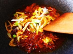 看见郫县豆瓣酱小火煸炒出红油后，加入葱姜丝爆出香味后。