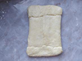 将醒发好的水面团用手稍微按压平整，把油面团包在其中。