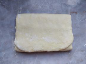 把混合的面团轻柔擀成长片，三折折好。