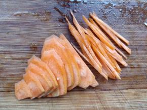 胡萝卜洗净，斜着切片。把切好的片斜着摞在砧板上，用左手压住上面的片不停移动，右手刀连续切丝即可。