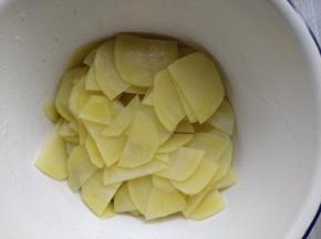 将切好的土豆片在热水里快速焯一下，到半熟的程度，捞出沥净水分备用。