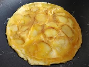 待表面蛋液八成凝固后，将饼快速翻面，让土豆片的那一面朝上，将剩余的蛋液倒在上面。八成凝固后再翻面一次。这样两面的土豆片和香肠片都煎熟了很香。