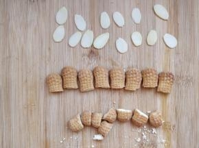 趁面包晾凉，挑选一些大小合适的杏仁片，将饼干切出合适大小。