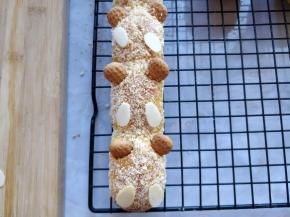 将饼干插在面包上恰当位置，充当耳朵。杏仁片用少许融化的白巧克力粘在面包上当小熊的手。