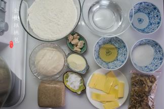 准备好所需要的食材，水取5%的量另装，做调整水使用。老面和烫种要提前一天制作，将215克水烧沸后倒入210克全麦粉中，揉至均匀后用保鲜膜裹好，放凉后冰箱冷藏第二天使用，老面可以是一天制作也可以用之前留下的老面，如果是手上有之前做的老面，那放140克老面即可