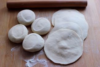 醒发好的面团排气揉匀后，用手搓成长条后，用刀切成大小一致的剂子，擀成圆形薄面皮。