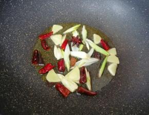 炒锅烧热倒入适量食用油，下入葱、姜、干红辣椒、八角和桂皮炒香。