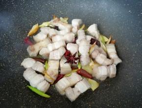 下入五花肉煸炒至出油。