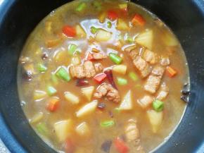 把炒好的菜肉连带汤汁一起倒进准备好的米饭里面，放入电饭锅，按正常煮饭键。