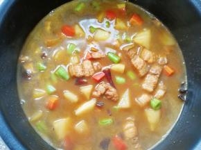 把炒好的菜肉连带汤汁一起倒进准备好的米饭里面，放入电饭锅，按正常煮饭键。
