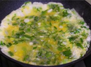 青辣椒和香葱切碎，加少许盐，打入鸡蛋拌匀。锅里倒入少许油，油热后倒入蛋液，炒熟。