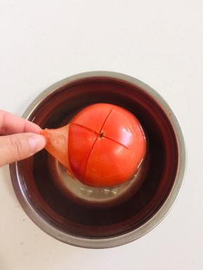 西红柿切十字花刀，用开水烫一下，扒掉外皮。