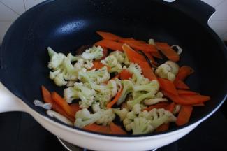 香菇先放，炒一下。因为香菇吸油会比较香，也可以根据自己的喜好顺序放。淖好的松花菜和胡萝卜片放入，炒两三分钟，放盐及酱油调味。