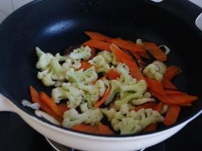 香菇先放，炒一下。因为香菇吸油会比较香，也可以根据自己的喜好顺序放。淖好的松花菜和胡萝卜片放入，炒两三分钟，放盐及酱油调味。