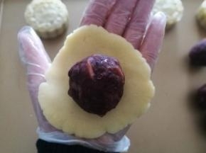 面团用手压扁包入馅料。