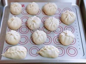 依次做完，放入蒸烤箱得蒸盘里，并垫上油纸！进行二次发酵，明显变大就可以用蒸！（我不太会捏包子的皱褶！汗）