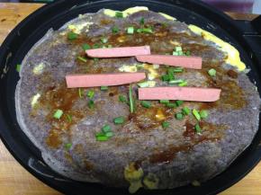 再翻面涂上酱，撒上香葱、放上香肠（喜欢辣的可以涂点辣酱）