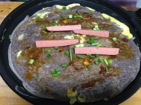 再翻面涂上酱，撒上香葱、放上香肠（喜欢辣的可以涂点辣酱）