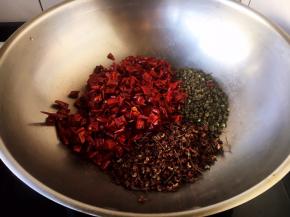 大火起锅，放入辣椒、花椒、麻椒。