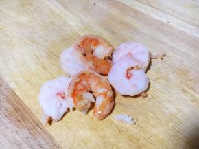 将熟虾仁对切，一切为二。