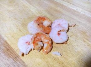 将熟虾仁对切，一切为二。