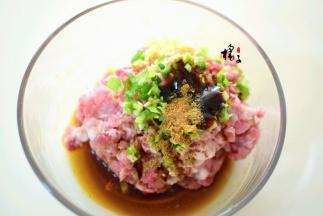 猪肉末中加入葱花和姜末,生抽，蚝油，料酒，锅中加热油浇入猪肉馅中