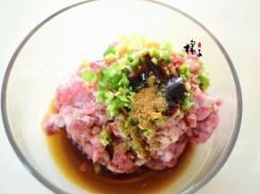 猪肉末中加入葱花和姜末,生抽，蚝油，料酒，锅中加热油浇入猪肉馅中