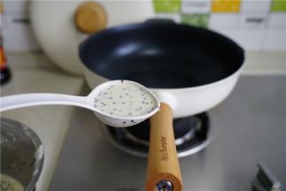 先大火预热好锅，再转小火，将面糊盛在锅里，摊至面皮又圆双薄。