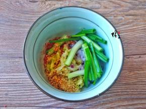 自制辣椒油：辣椒面、蒜末、葱段、芝麻、盐放在一个碗中