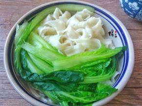 把烫好的白菜捞出放面条碗中，