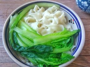 把烫好的白菜捞出放面条碗中，