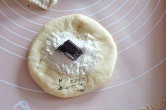 将白糖粉舀1-2勺放在面中央，中间放一块巧克力。