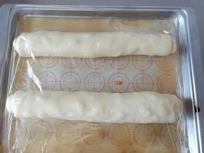 10.摆入烤盘，盖保鲜膜。烤箱中放一碗温水，打开发酵功能进行二发
