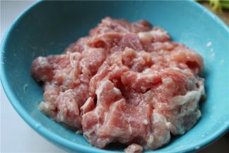 制作面条的时候，开始准备焖面的配菜。先把里脊肉切成片，加入水淀粉、少许盐和一勺油，拌匀腌制10分钟，这样炒出来的肉口感会特别嫩，而且炒多久也不会老。