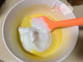 舀一大勺蛋白到蛋黄糊里。