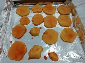 取一个烤盘铺上锡纸，把腌制好的土豆片码在烤盘上