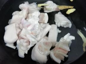 锅里加入适量的水，再加入料酒和姜片，再把猪蹄放入锅中，焯水去除血沫