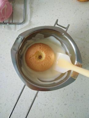 15将甜甜圈光滑一面放入白巧克力中，用手按压，使四周都均匀的裹上巧克力。