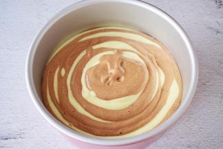 就这样一勺原味一勺可可，直至所有的蛋糕糊用完，端起模具的两端，轻轻震几下，震出大气泡