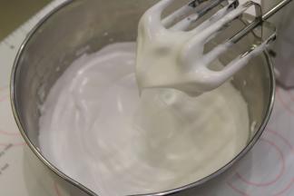 糖浆呈细线状倒入蛋白内，一边倒入一边打发，打蛋头提起呈鹰嘴状。