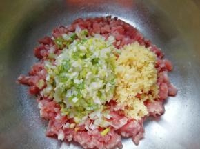 准备好肉馅，放上剁碎的生姜和大葱。