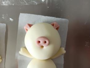 粘到猪猪的头部合适位置，把耳朵尖压下来粘住