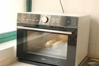 包好锡纸的鸡腿卷放入美的蒸烤箱，选择石窖烘烤功能，230度烤40分钟左右。